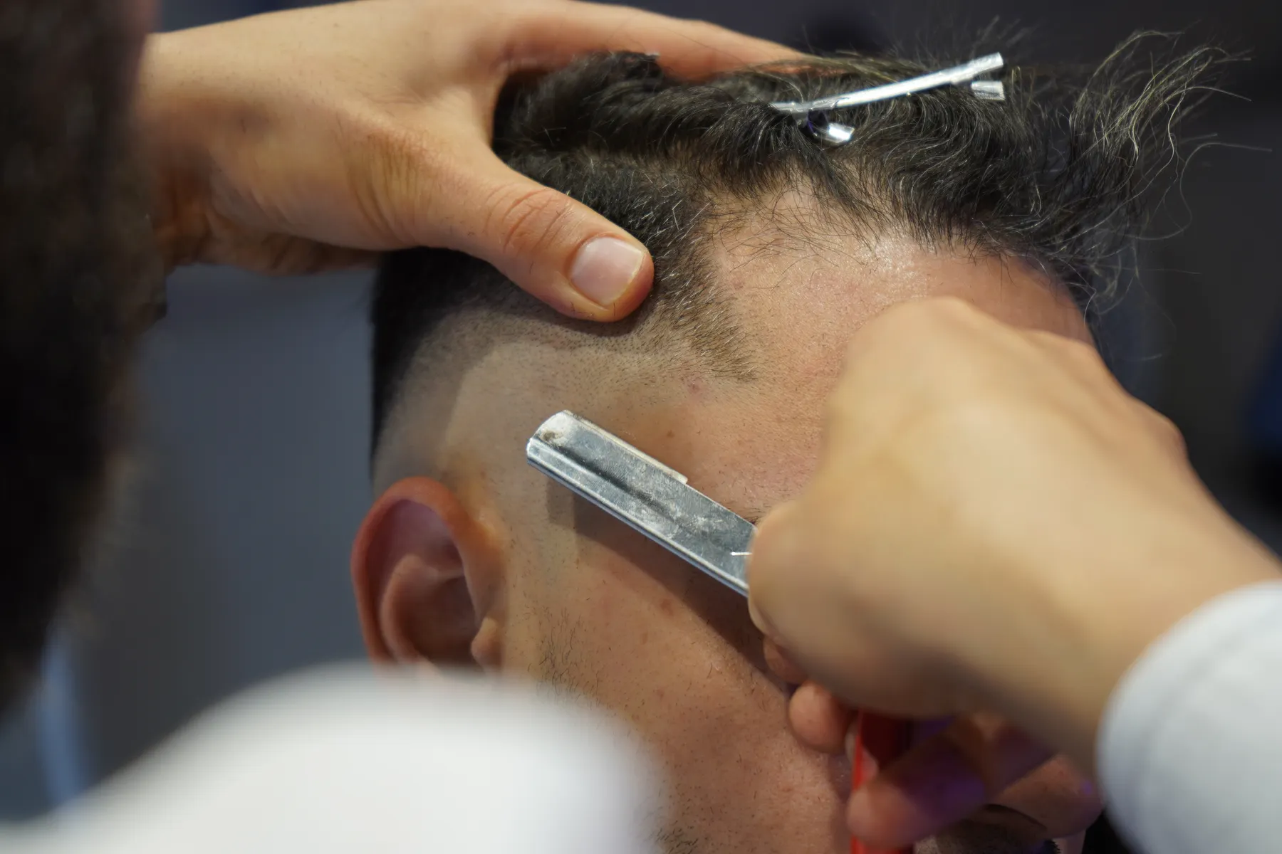 Barbeiro fazendo o acabamento de um corte
